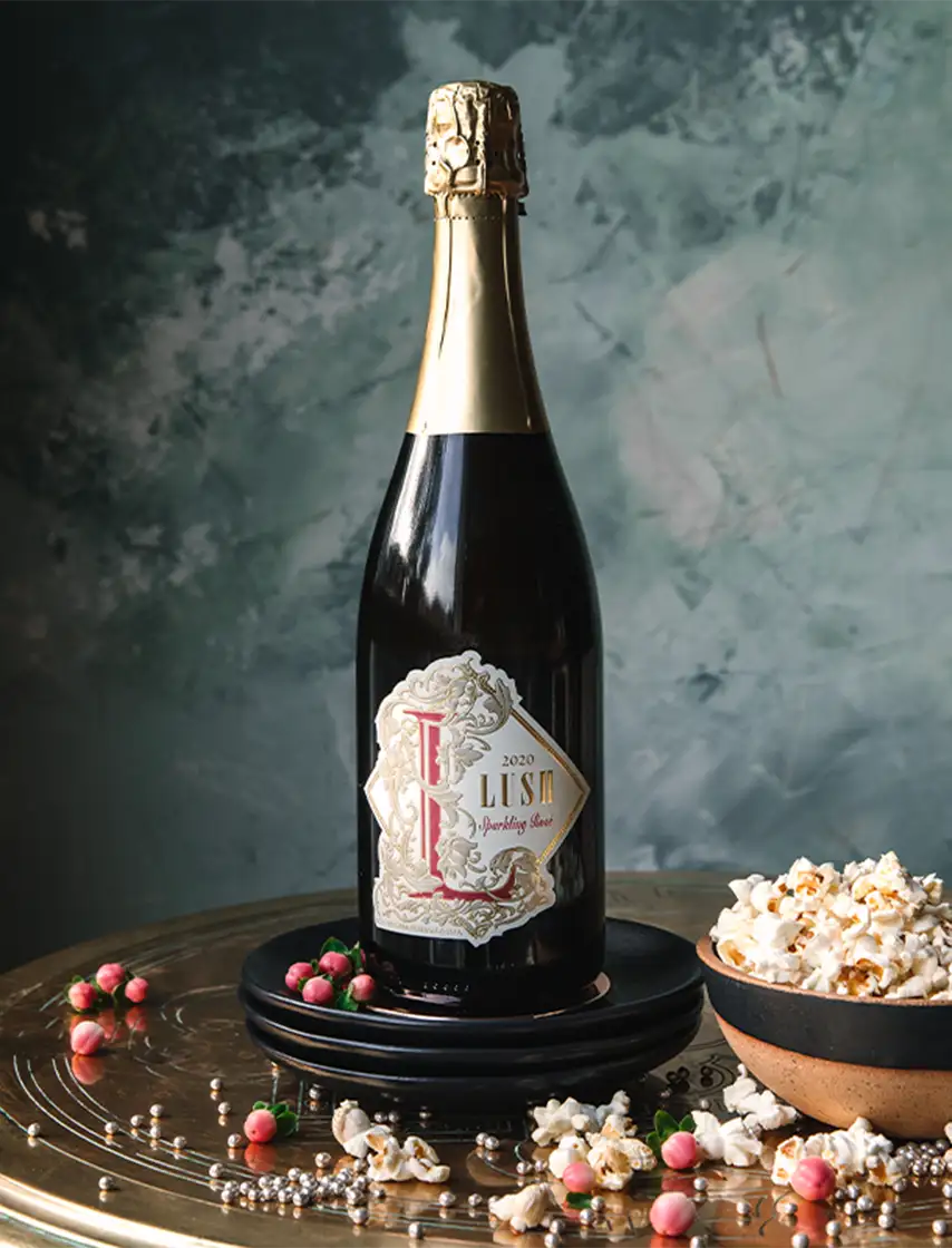 Two Sisters Vineyards Wine beside a bowl of popcorn.