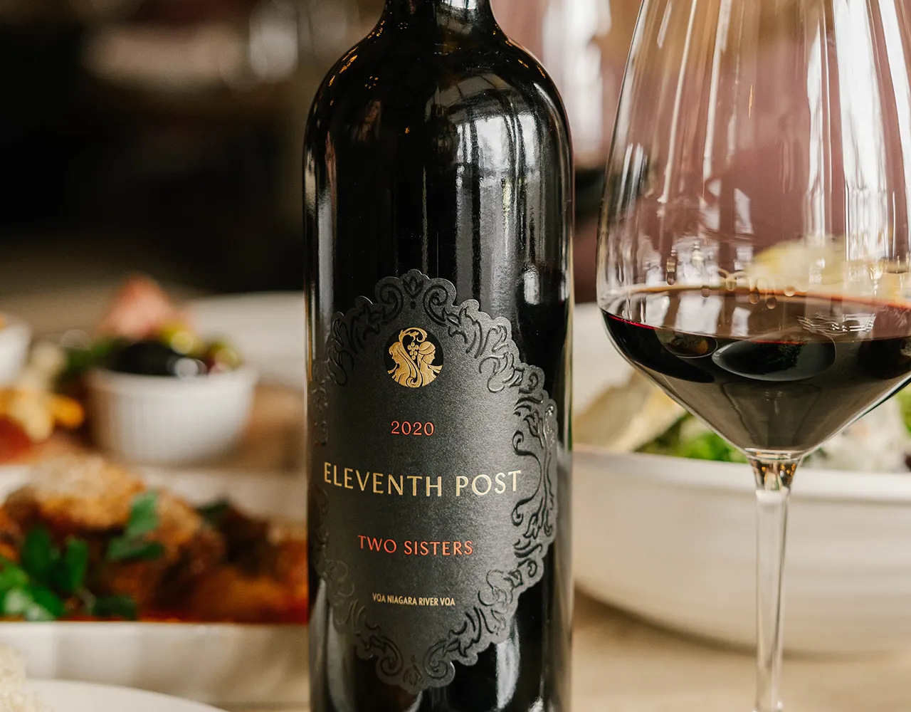 Two Sisters Eleventh post on Queen wine on a table. 